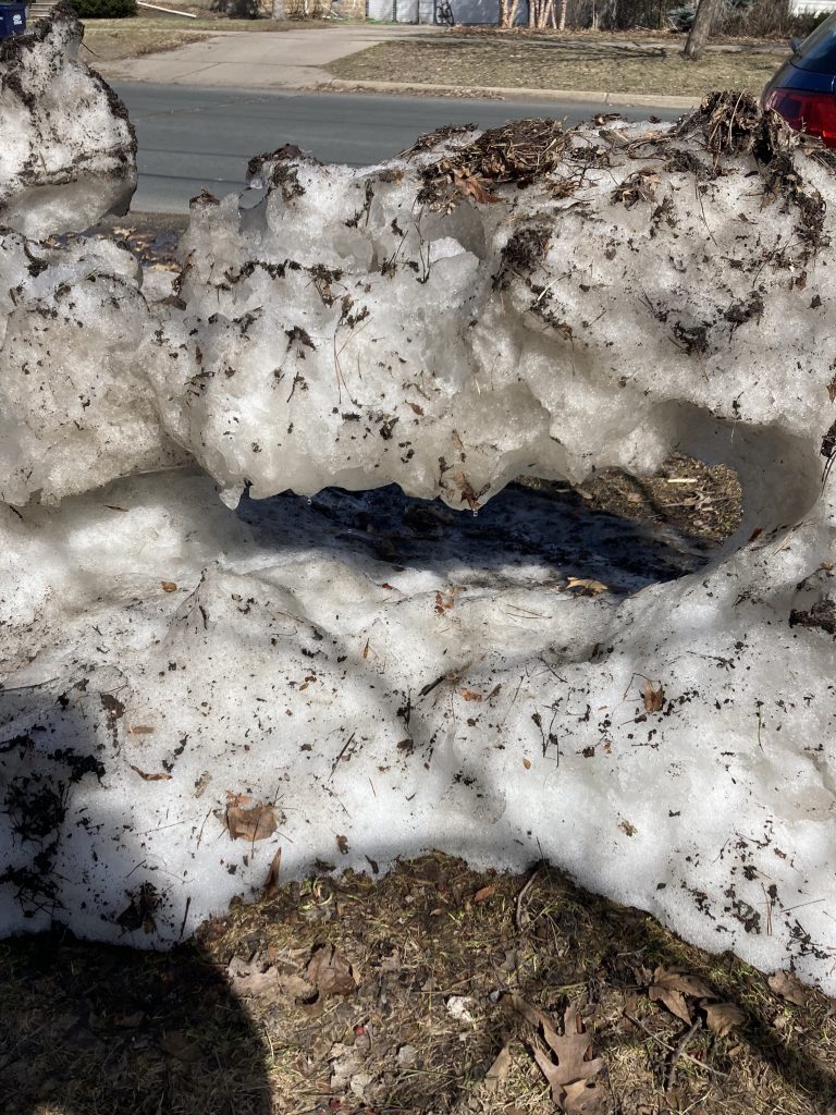 pile of ice with large, dripping hole in through the center