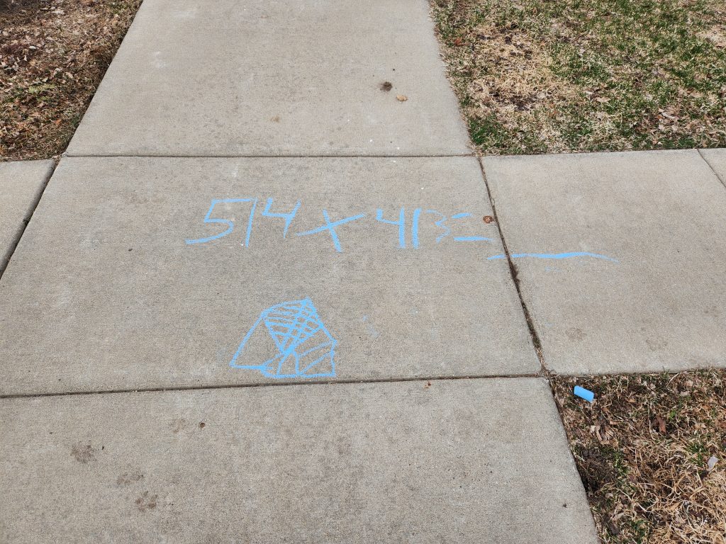 A math problem written in sidewalk chalk.