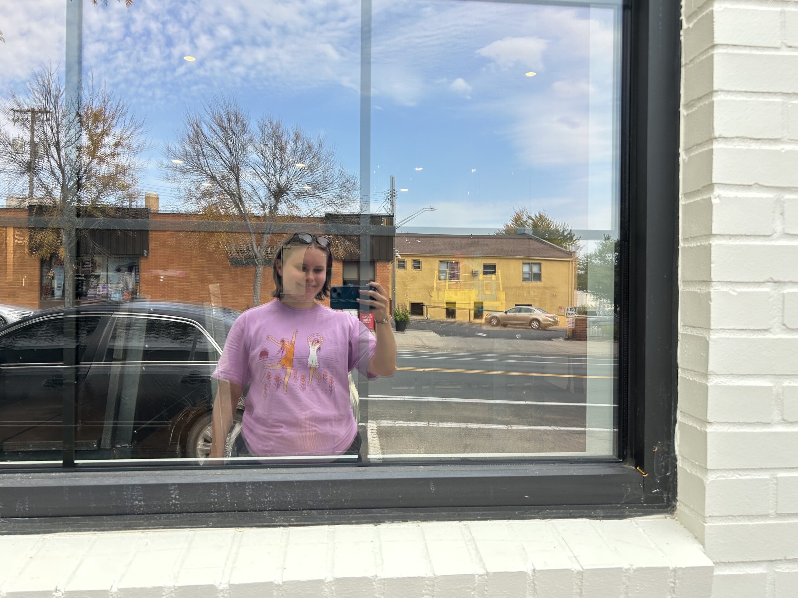 Stella taking a selfie in the reflection of a window