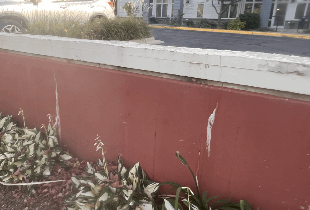 Close-up of a red half-wall in front of Village on the Cannon